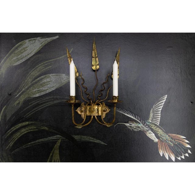 A striking Spanish wall-mounted candle sconce in medieval revival style, dating to circa the 1950s. Crafted from gilt...