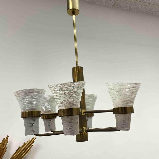 Mid-Century Modern chandelier made in the 1960s. It has six arms, each with glass shade in extraordinary shape. The light...