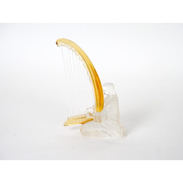 This elegant French crystal sculpture by the renowned Saint-Louis crystal house depicts a seated musician playing a tall,...