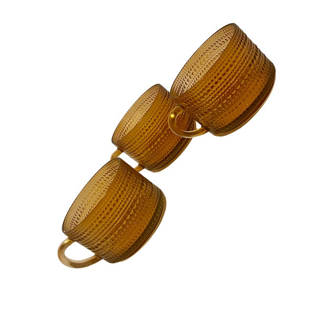 A beautiful set of three authentic Iittala Kastehelmi coffee cups in rich amber glass, designed by renowned Finnish glass...