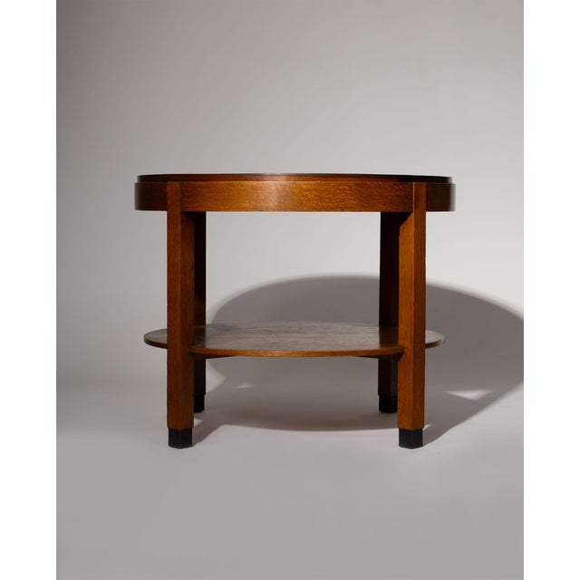 A finely crafted round side table in oak, simple yet expressive, exemplifying the Amsterdam School’s functional design....