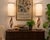 Exceptional pair of Mid-Century Modern table lamps featuring sculptural walnut bodies, polished brass accents, and elegant...