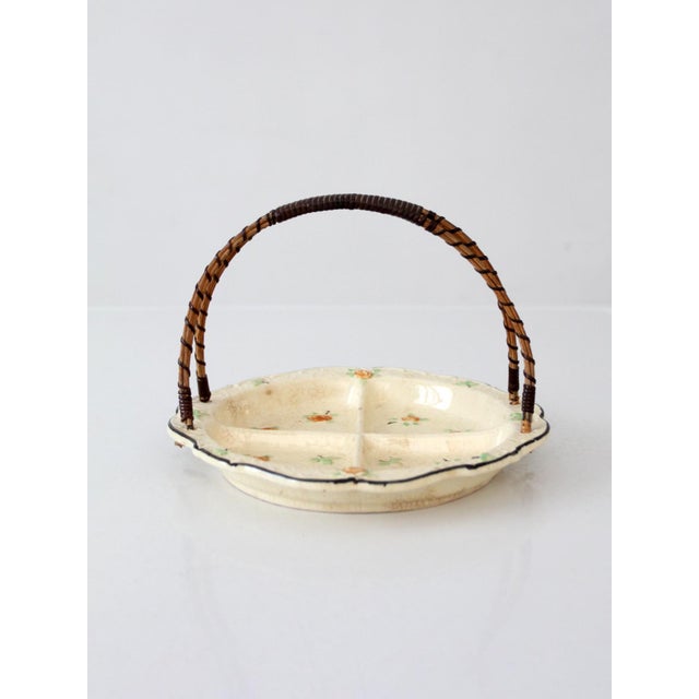 A vintage Japanese porcelain serving dish featuring a divided four-section interior adorned with delicate scattered floral...