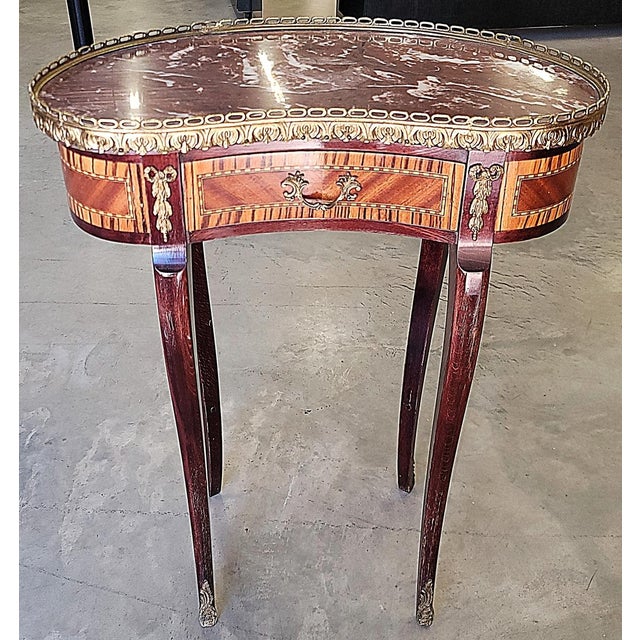 Such a classic, this French kidney shape petit table on tapered cabriole legs, brass adornments throughout, cinnamon...