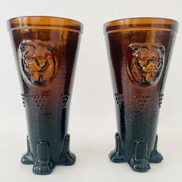 Beautiful set of rare mid-century lion vases in amber ocher glass from the 1970s. This pair of flared cone-shaped belly...