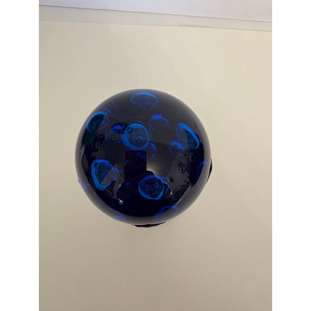 This beautiful cobalt/arctic blue Murano hand blown glass paperweight which is housed in a mid-century modern Hollywood...