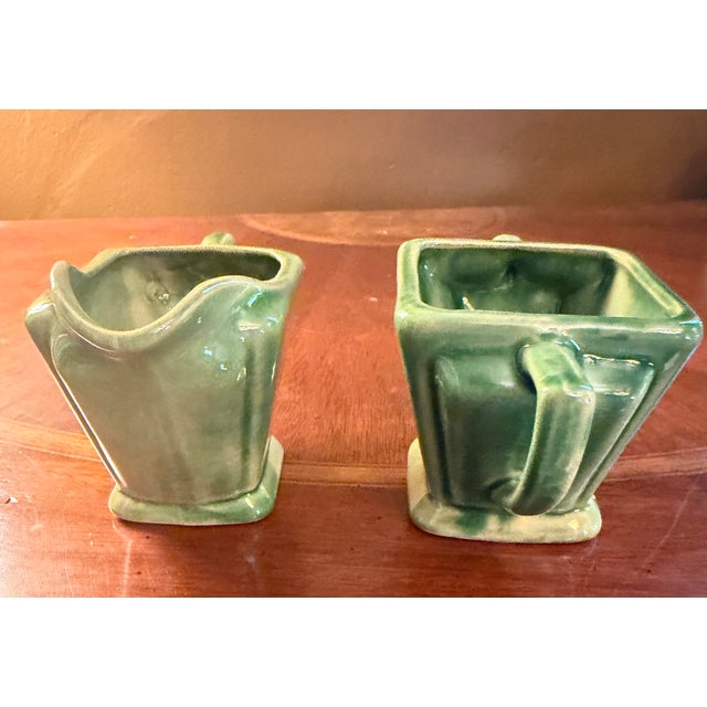 The Anna Van Briggle Art Deco Pottery Green Glaze Creamer & Sugar set from around 1955 exudes vintage charm with its Art...