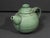 A sculptural handmade studio pottery teapot distinguished by its rounded form, softly ribbed surface, and richly textured...