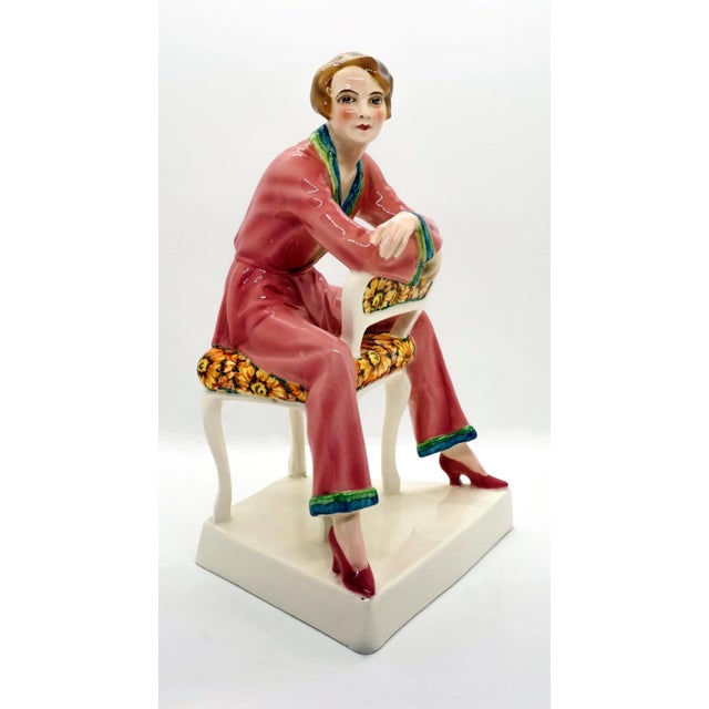 Very rare goldscheider ceramic figurine. The young lady with a brunette page-boy hair cut is wearing pink pajamas with...