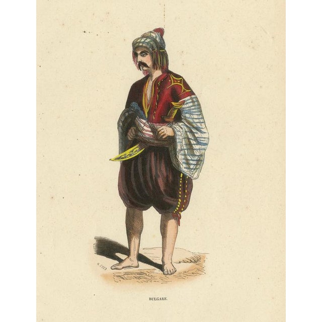 This lithograph portrays a Bulgarian man dressed in regional costume, complete with sash, headwear, and distinctive...