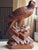 A Black Forest wood carving of an eagle with glass eyes perched on a rocky outcrop, crafted from walnut wood. Masterfully...