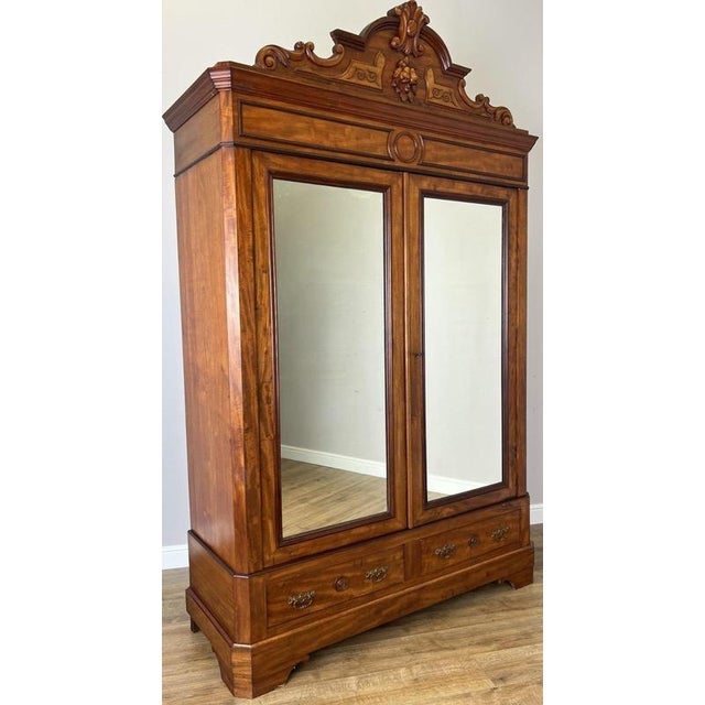 This impressive Antique French wardrobe is a beautifully crafted piece featuring a rich mahogany finish, elegant mirrored...