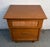 A charming mid-century modern walnut nightstand featuring a distinctive cane-faced drawer that adds texture and visual...