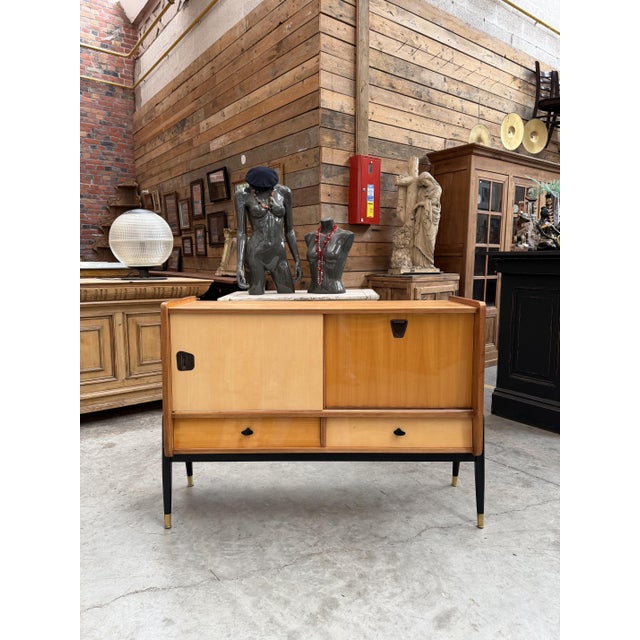 This 1950s piece of furniture was designed by Oswald Vermaercke. It features a sliding door that opens onto a shelf and a...