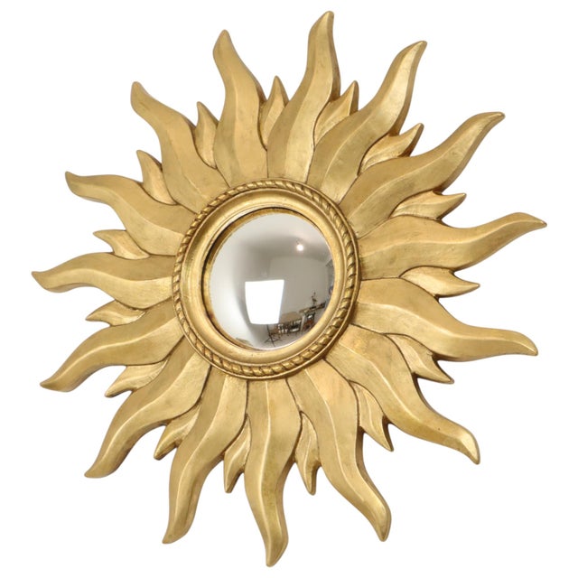 Large vintage sunburst mirror featuring convex glass and layered rays; crafted from gold-colored resin, this is an...
