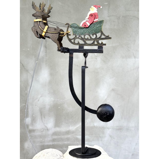 Charming vintage Christmas balancing toy featuring Santa Claus in a decorative sleigh pulled by two reindeer. This...