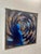 Striking mid-century contemporary artwork featuring a blue-toned female figure set against a dynamic spiral abstraction....