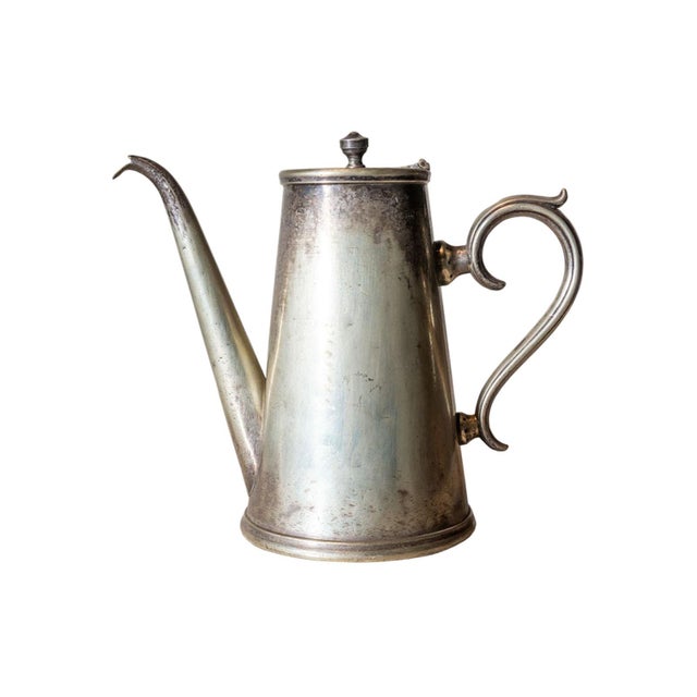 Antique metal serving pitcher with curved handle and spout. Hinged lid with finial. Maker's mark on bottom.