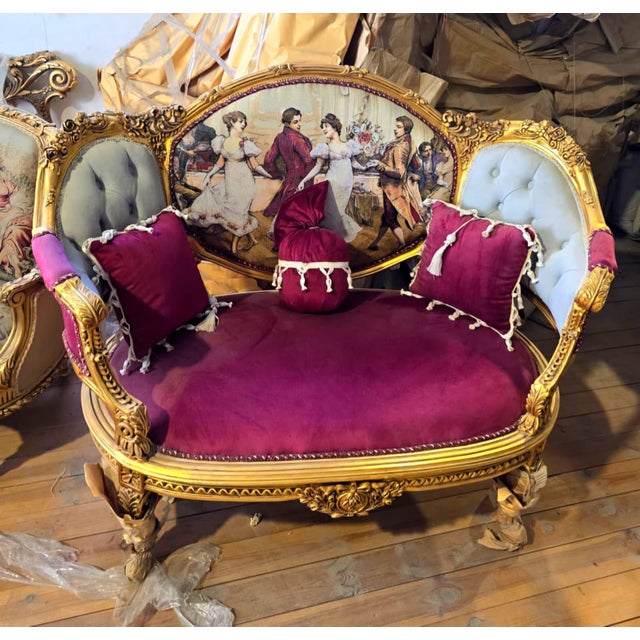 French Victorian loveseat. Upholstered in luxurious burgundy velvet, this exquisite piece is beautifully accented with an...