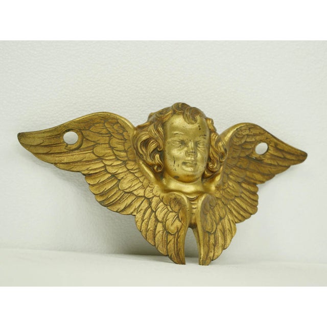 Gilded brass wall mounted angel. Good condition with appropriate wear from age. One available. The manufacturer and exact...