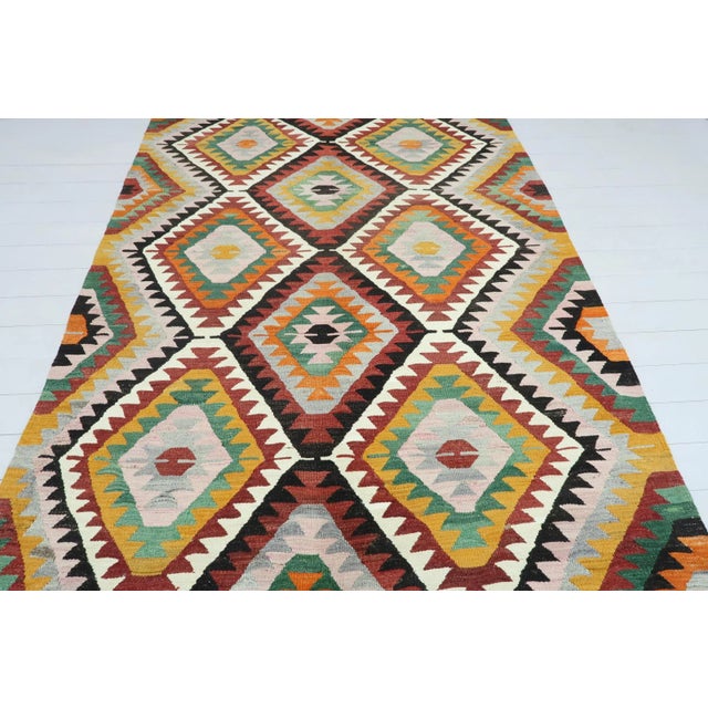 This Turkish Kilim rug hosts an intriguing pallet of vibrant rich and pastel colourways complementing a very Turkish sense...