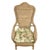 Vintage high-back wicker and rattan armchair featuring a sculptural shaped back, woven arms, and removable floral seat...