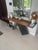 A striking console table featuring a warm medium-toned wood surface paired with a bold, sculptural black base. The...