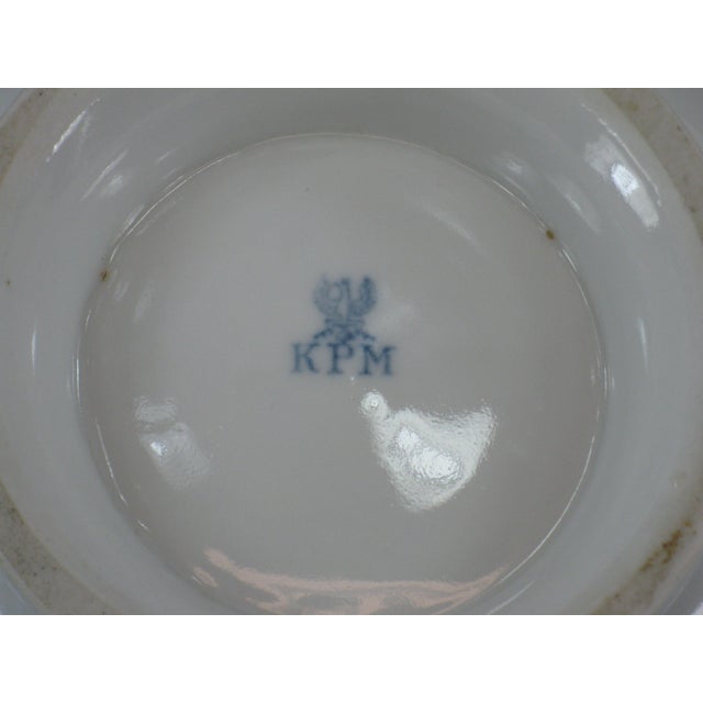 This German KPM porcelain bowl features a floral pattern with grape leaf edges, hand-painted with gold accents. Made in...