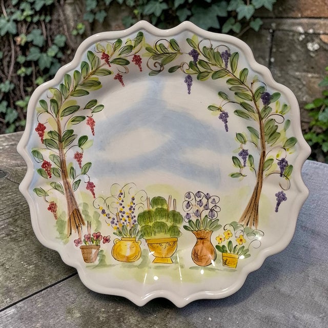The Vintage "Ma Maison" Hand Painted Collection Garden Scene Scalloped Edge Platter is a beautifully crafted ceramic piece...