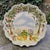 The Vintage "Ma Maison" Hand Painted Collection Garden Scene Scalloped Edge Platter is a beautifully crafted ceramic piece...
