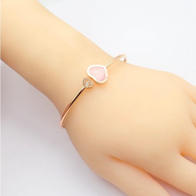 Rare Chopard Happy Hearts bracelet crafted in 18k rose gold, featuring a large pink opal heart paired with a smaller heart...