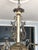 Elegant French silver/pewter 6-arm chandelier. The arms feature elegant scroll work while each bobeche is enhanced with...