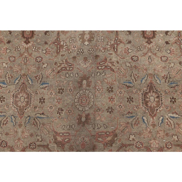 An early 20th century Persian Tabriz antique carpet, the camel field with a rose, blue and beige lattice overall of...