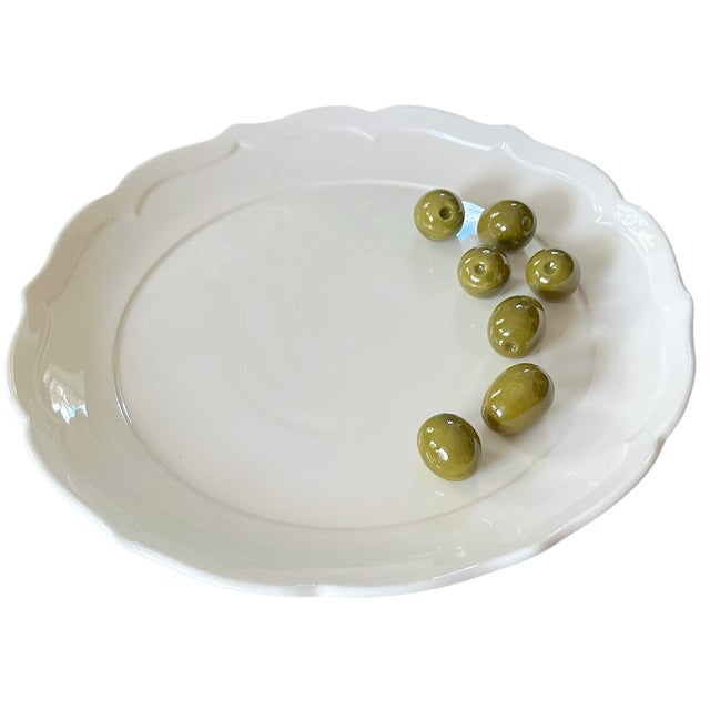 A little visual mischief for the cocktail hour. Seven glossy green ceramic olives are sculpted onto one side of this...