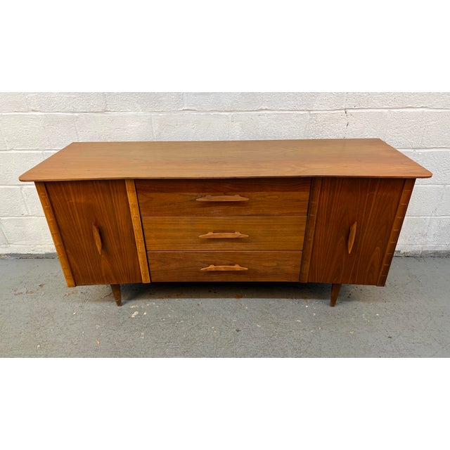 A beautifully crafted Mid-Century Modern walnut credenza by the highly regarded Young Manufacturing Company, showcasing...