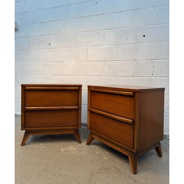 Elegant pair of Mid-Century “Distinction” walnut nightstands by Unagusta, showcasing the warm walnut tones, clean lines,...