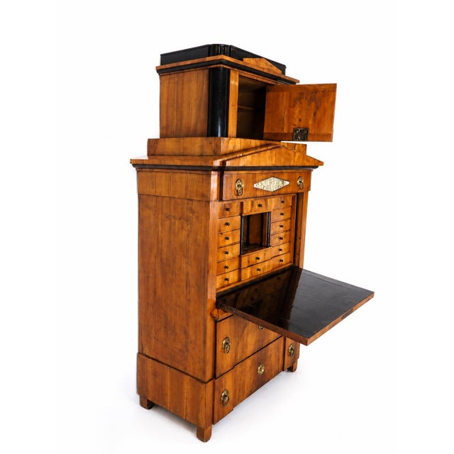 A rare and exceptionally refined Biedermeier secretary cabinet in beautifully figured cherrywood, surmounted by its...