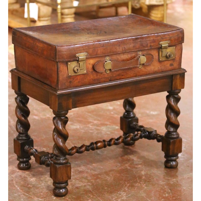 This refined antique suitcase table features a 19th century leather traveling case mounted on a later walnut stand...