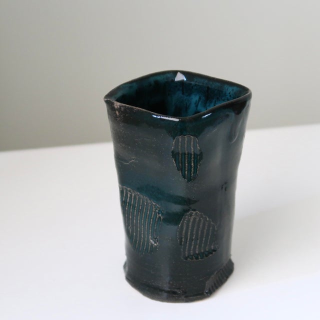 Handmade studio pottery ceramic vase finished in a rich, deep teal glaze with black tonal variation and sculptural carved...