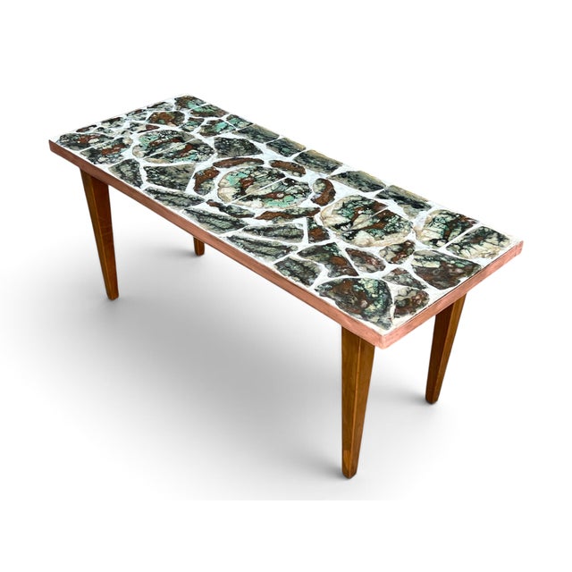 A striking blend of natural artistry and Mid-Century Modern design, this vintage coffee table features an extraordinary...