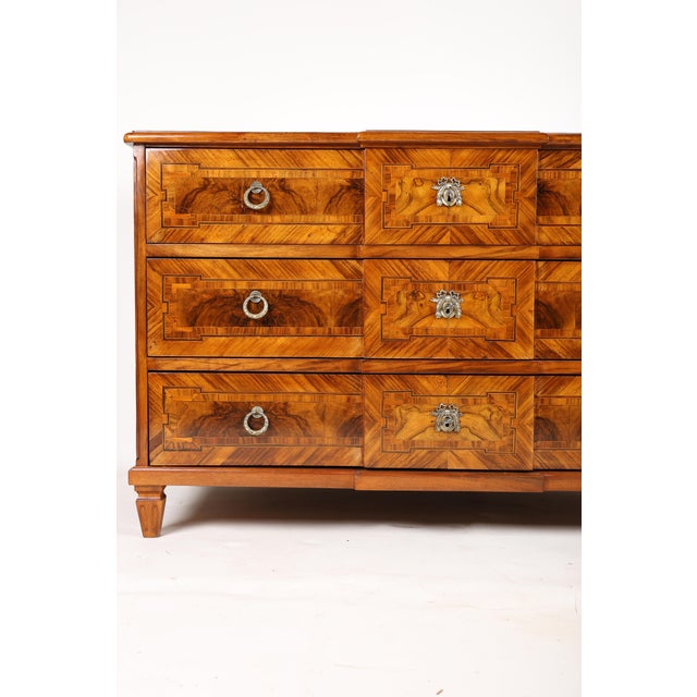 A very beautiful walnut chest of drawers in an elegant design, with three drawers featuring brass fittings, box locks, and...