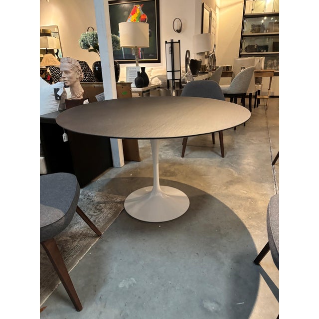 Knoll Eero Saarinen Round Pedestal Dining Table with Dark Top and White Tulip Base A timeless icon of mid-century modern...