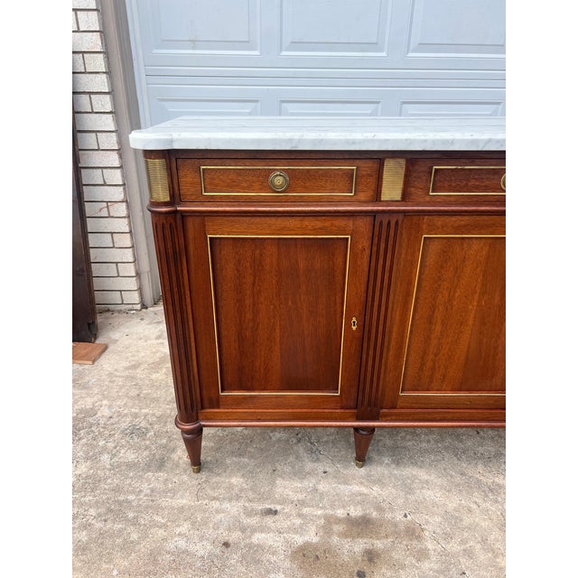Elegant 19th century Louis XVI buffet crafted from rich mahogany, featuring a luxurious Carrara marble top, four drawers...