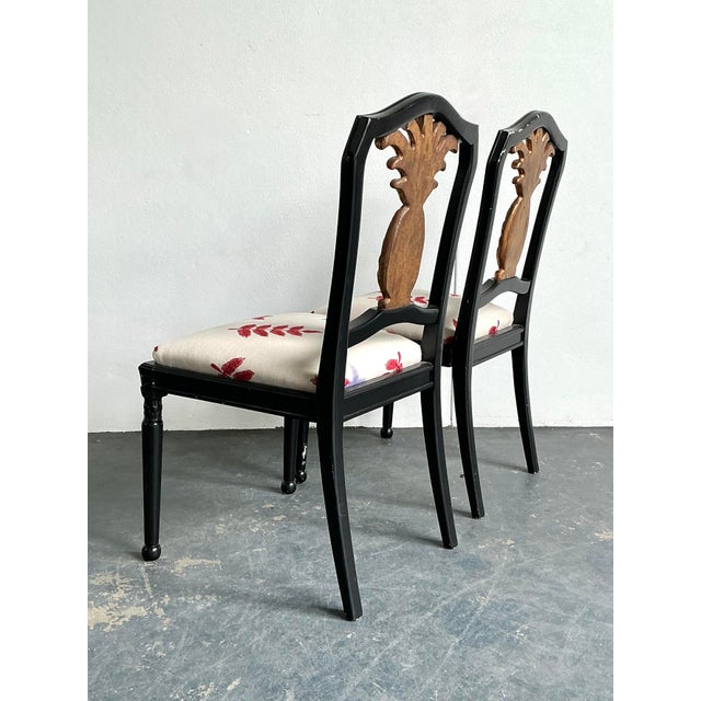 This stunning pair of vintage side chairs is a masterclass in Hollywood Regency glamour, featuring a bold black lacquered...