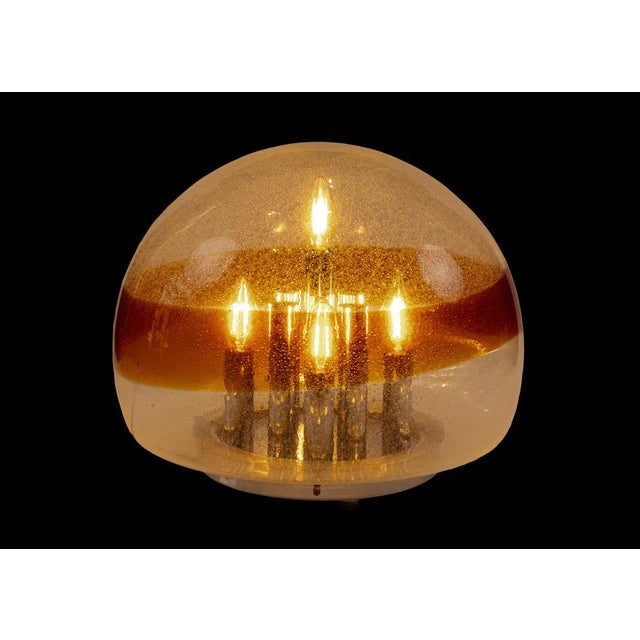 The piece features a spectacular semi-spherical diffuser made of blown Murano glass, combining an elegant translucent...