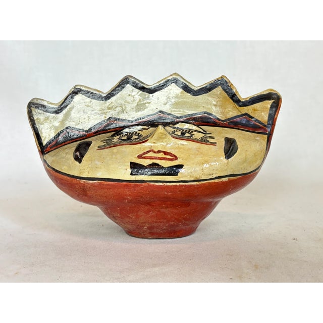 This beautiful jug depicts a face and has hair in a zig zag pattern.