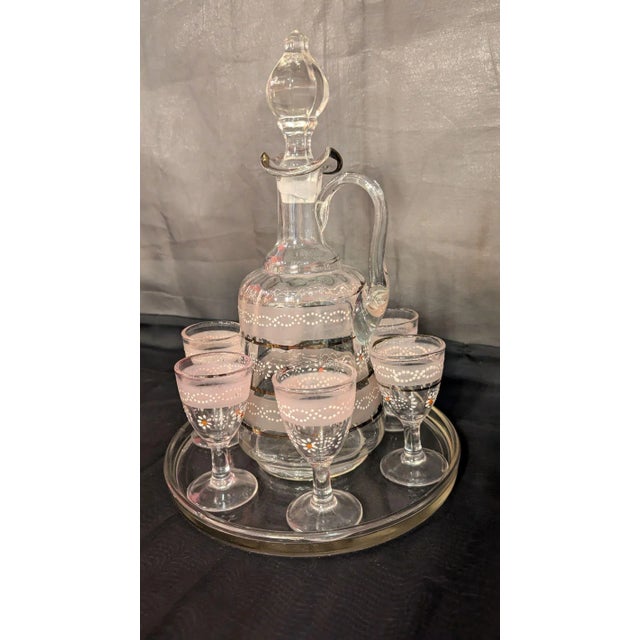 Pretty in Pink overlay ribbing with subtle daisy enamelwork, and silver linework. Decanter with stopper, tray, and 6...