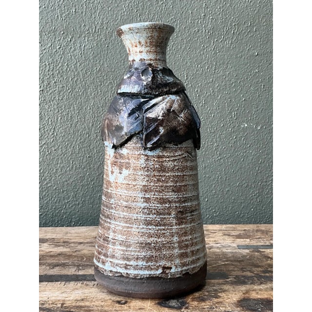 This vintage handcrafted ceramic vase embodies rustic, artisanal charm characteristic of mid-20th-century studio pottery....