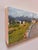 This oil on board painting captures a winding road that curves gently around a bend, leading the viewer's eye toward...