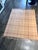This is a camel-colored windowpane throw blanket featuring a classic large-scale plaid pattern and fringed edges, similar...